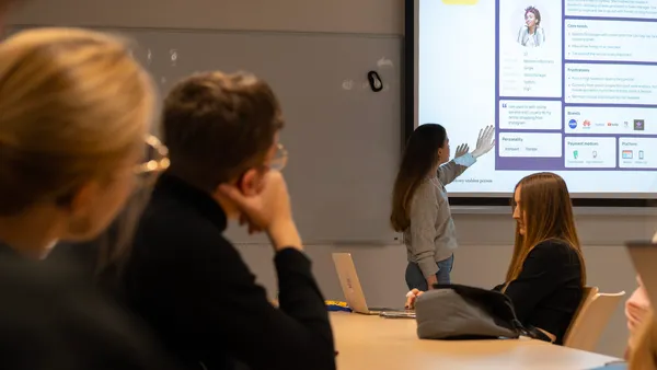 Julia presenting a persona template to a classroom during a design-thinking lecture at AGH.